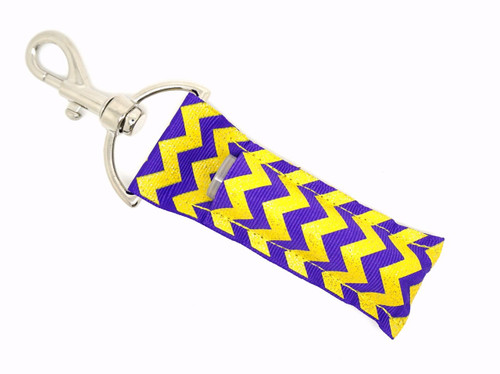 Lip Balm Holder Purple and Yellow Glitter Chevron  

Purple and Yellow Glitter Chevron lip balm holder! This beautiful Lip Balm or Chapstick Holder is HANDMADE with a high-quality materials! Our unique design and clasp offer both style and functionality. The hook is on a swivel head so the lip balm always falls back down and never gets stuck upside down, this is where most lip balm holders lose your lip balm or chapstick! This lip balm holder is designed to snuggly fit any standard lip balm or chapstick. Make sure your lip balm or chapstick will not get lost and grab one of these! 

BENEFITS: Misplacing or Losing your lip balm or chapstick is the worst!! Don’t let that happen again and buy the perfect solution! Our Lip Balm / Chapstick Holder Keychain will make sure you always have your Gettin Lippy lip balm at hand when desperately needed. Our cute fun designs will compliment anything. Attach it to your keys, lanyard, back-pack, bag, purse, or anywhere your little heart desires with our easy open clasp!  

PERFECT GIFTS: A simple gift can go a long way. Everyone needs something cute and functional. Buy now for stocking stuffers, birthday party, a team gift or for a daughter, friend, wife, girlfriend, colleague, student, teacher, etc! 

BUY WITH CONFIDENCE: Read the reviews! Our Gettin Lippy Lip balm holders are the number one rated lip balm holders on the market! If you don’t LOVE our product, we offer 100% Money Back GUARANTEE no questions asked. 

PACKAGE INCLUDES:  1 Unique Lip Balm / Chapstick holder. Each Holder is 6.5 inches (with hook) x 1.5 inches. **NOTE: Gettin Lippy lip balms in pictures are not included but click on the link below and get the best multi-flavored lip balm on the market: https://gettinlippy.com/lip-balms-collegiate-line/uni-panthers-lip-balm/  

HANDMADE IN THE USA!!