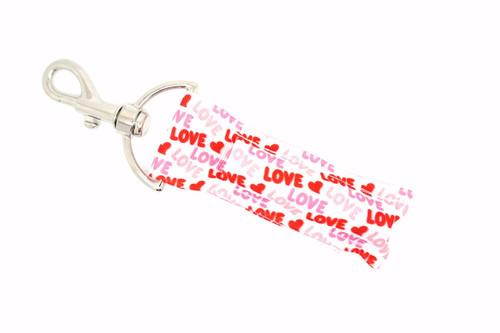 Love Struck - LOVE & Hearts Valentine Lippy Clip

Say it loud, say it proud – you're Love Struck! This adorable lippy clip is all about sweet simplicity and heartfelt charm, featuring a white background with “LOVE” and tiny hearts in red, pink, and blush tones.

Whether you're gifting a Valentine, treating yourself, or just showing your love year-round, this cute and functional lip balm holder keeps your chapstick close while turning up the romance.

Why You’ll Love It:

Classic Valentine color palette: Red, Pink, and Light Pink
Repeating “LOVE” print and tiny hearts
Silver lobster clasp clips easily to keys, purses, or backpacks
Great for Valentine’s Day, anniversaries, or just because
Holds most standard lip balms and glosses snugly

Product Details:

Design: White background with “LOVE” and small hearts in red, pink, and light pink

Material: High-quality printed fabric

Clip: Silver clasp for secure, easy attachment

Size: Fits most standard-size lip balms and roller bottles

Includes: 1 Love Struck lip balm holder (lip balm not included)

Handmade with love by Gettin Lippy in the USA