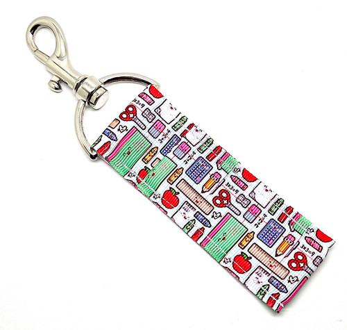 “Teachers Rule” – Teachers Lip Balm Holder

Teachers really do rule — and now they can keep their lips looking as polished as their lesson plans! Our “Teachers Rule” Lip Balm Holder is the perfect mix of cute, clever, and totally classroom-ready.

This tidy and colorful design features a white background with neatly lined illustrations of rulers, apples, crayons, calculators, notebooks, and more, creating a crisp, organized look that any teacher will adore. It’s bright, cheerful, and practical — just like your favorite educator!

Clip it to your keys, lanyard, tote, or teacher badge and you’ll never lose your lip balm again. Whether you’re grading papers or running the classroom, this little holder will keep your balm handy through every school day.

Why You’ll Love It

Smart & Stylish Design:
Perfectly lined-up school supplies and bright pops of color make this holder as organized and charming as your favorite teacher.

High-Quality Printed Fabric:
Soft, durable, and vibrant — ready to handle even the busiest classroom chaos.

No More Lost Lip Balm:
The sturdy swivel clasp attaches easily to lanyards, purses, or bags, keeping your balm right where you need it.

The Perfect Teacher Gift:
Fun, affordable, and functional — ideal for teacher appreciation, back-to-school, or a “just because” surprise.

Handmade in the USA:
Each holder is crafted with love and care — teacher-approved quality that lasts!

Perfect For:

Teachers, aides, and school staff

Back-to-school or appreciation gifts

Cute classroom accessories

Practical, affordable gifts for educators

Anyone who loves bright and organized school-themed designs

Product Details

Dimensions: 6.5 inches (with hook) x 1.5 inches

Includes: 1 Lip Balm Holder (lip balm not included)

Material: High-quality printed fabric

Handmade in the USA

Pair it with your favorite Gettin Lippy lip balm, keychain wristlet, or teacher-inspired gift set — because fabulous lips are always in session.