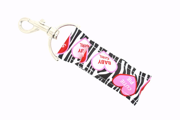 Zebra Sweets Lippy Clip - Valentine Candy Heart Lip Balm Holder

Sweet and wild collide in Zebra Sweets, the perfect Valentine’s Day lip balm holder for anyone who loves a little sass with their sugar! Featuring a bold white and black zebra-striped background and adorable Valentine’s Day candy hearts in soft pinks, red, and white with flirty sayings like Cutie Pie, Baby Girl, and Sweetheart — this lippy clip is a whole mood.

Clip it to your bag, keys, or purse and take your lip balm everywhere with fierce Valentine energy. Whether you're gifting it or flaunting it yourself, Zebra Sweets is a sweet treat you’ll love year-round.

Why You’ll Love It:

Candy heart charm with wild flair
Bold zebra print background
Holds standard lip balm tubes securely
Easy-to-use lobster clasp
Perfect gift for Valentine’s Day or “just because”

Product Details:

Design: White and black zebra background with baby pink, red, and white Valentine hearts that say "Cutie Pie," "Baby Girl," and "Sweetheart"

Material: High-quality printed fabric

Clip: Durable silver lobster clasp

Size: Fits most lip balm brands

Includes: 1 Zebra Sweets lip balm holder (lip balm not included)

Handcrafted by Gettin Lippy in the USA