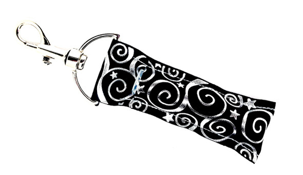 Midnight Magic – Black & Silver Swirl Star Lip Balm Holder Keychain

Step into the shimmer of the night with Midnight Magic—a celestial-inspired lip balm holder designed to dazzle. Set against a rich black background, this keychain features stunning raised silver foil swirls and twinkling stars that sparkle with every turn. Perfect for dreamers, stargazers, and anyone who loves a touch of cosmic glam!

Clip it to your keys, purse, or backpack to keep your favorite chapstick close and your style truly stellar.

Why You’ll Love It:
Starry-Eyed Style – Raised silver foil swirls and stars shine bright
Elegant Contrast – Black background makes the silver pop
Chic & Convenient – Keep your lip balm easy to reach and hard to lose
Gift-Ready Glam – Great for holidays, birthdays, or just because
Product Details:
Size: Approx. 6.5" x 1.5"
Material: High-quality printed fabric
Includes: 1 Midnight Magic lip balm holder (lip balm not included)

Handmade with love by Gettin Lippy in the USA