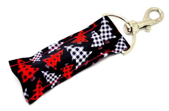 Buffalo Tree Bling – Festive Christmas Tree Lip Balm Holder Keychain

Bring the cozy charm of Christmas right to your keys or bag with the Buffalo Tree Bling lip balm holder. Featuring a black background with eye-catching red and white buffalo plaid Christmas trees, this festive essential is the perfect combination of trendy and traditional.

Clip it to your purse, backpack, or holiday gift bags for easy access to your favorite chapstick and a little touch of holiday flair wherever you go.

Why You’ll Love It:

Festive & Stylish – Buffalo plaid trees for a rustic holiday look

Perfect Gift Idea – Great for stocking stuffers, Secret Santa, or gift toppers

Functional Fashion – Holds most standard lip balms securely

Easy to Clip On – Includes sturdy keyring and clasp

Product Details:

Size: Approximately 6.5" x 1.5"

Material: High-quality printed fabric

Includes: 1 Buffalo Tree Bling lip balm holder

Note: Lip balm not included

Handcrafted in the USA