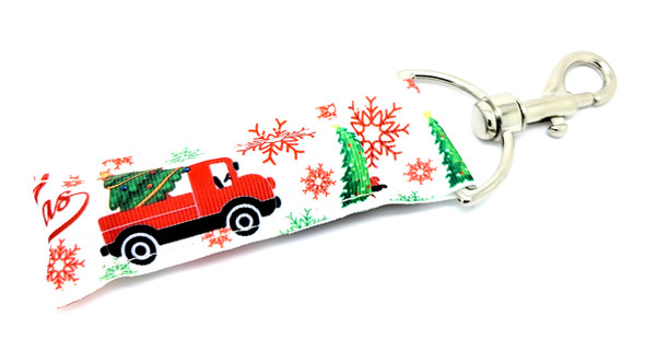 Tree Haulin’ – Vintage Red Truck Christmas Lip Balm Holder

Capture the cozy charm of the holidays with our Tree Haulin’ lip balm holder! Featuring a snowy white background, classic red trucks loaded with Christmas trees, standing pines, and delicate snowflakes, this festive keychain is a nostalgic nod to holiday traditions.

Whether you're cutting down your tree or dashing through errands, this handy chapstick holder keeps your lip balm right where you need it—in style!

Why You’ll Love It:

Vintage Vibes
The timeless red truck with a tree in tow gives this holder a farmhouse Christmas feel.

Festive Functionality
Clip it to your purse, keys, or backpack and never lose your chapstick in the bottom of your bag again.

Great for Gifting
Perfect as a stocking stuffer, holiday party favor, or gift for Christmas lovers of all ages.

Product Details:

Size: Approx. 6.5" (including clip) x 1.5"

Material: High-quality fabric with snowy winter scene

Includes: 1 Tree Haulin’ lip balm holder

Note: Lip balm not included

Handmade with holiday cheer in the USA