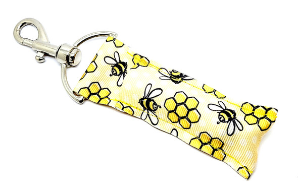 Bee Doodle Buzz – Sketched Honey Bee & Honeycomb Lip Balm Holder

Add a splash of sunshine and a dash of whimsy to your day with our Bee Doodle Buzz Lip Balm Holder! This fun and creative accessory features a golden yellow background with hand-sketched-style bees and honeycomb. The artistic design gives it a fresh, modern twist on a classic garden theme.

Whether you're a bee enthusiast, a fan of rustic art, or just love a good splash of yellow, this lip balm holder brings charm and convenience together in one buzzing package.

Why You'll Love It:

Sketchbook-Inspired Style
The charming, rough-sketch illustrations of bees and honeycomb add an artistic flair — perfect for those who love handmade, rustic, or cottagecore vibes.

Never Dig for Your Lip Balm Again
Swivel clasp clips easily onto keys, bags, or backpacks — your favorite balm is always within reach.

Handmade Quality
Proudly handcrafted in the USA with premium materials and durable hardware. Made to last, made with love.

Gift-Ready for Any Occasion:

Bee & nature lovers

Rustic or farmhouse decor fans

Teacher gifts & thank-you baskets

Spring/summer birthdays

Just-because happy mail!

100% Satisfaction Guarantee
Love it or your money back — no questions asked.

Product Details:

Size: 6.5 inches (including clasp) x 1.5 inches

Material: High-quality woven fabric and secure clasp

Includes: 1 Bee Doodle Buzz Lip Balm Holder

Note: Lip balm not included — pair it with our Gettin’ Lippy lip balms!

Handmade in the USA