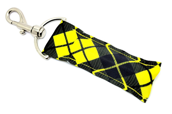 Midnight Edge Lip Balm Holder – Dark Diamond Style in Black & Yellow

Make a sharp impression with the Midnight Edge Lip Balm Holder — a sleek, high-contrast accessory that fuses dark plaid style with practical convenience.

Featuring a deeper black and yellow diamond pattern, this design delivers serious attitude. Whether you're repping your favorite team colors or just vibing with bold, graphic looks, this holder keeps your chapstick handy while turning heads.

Perfect for night owls, trendsetters, and anyone who craves utility with a touch of edge.

Why You'll Love It:

High-Contrast Style
The bold plaid pattern is elevated with a deep black base and sharp yellow highlights. Sleek, modern, and fashion-forward.

Keep It Close
Never dig through your bag again! The sturdy swivel clasp attaches easily to keyrings, backpacks, and totes.

Handmade in the USA
Crafted with premium fabric and hardware, this durable lip balm holder is designed to last — and look good doing it.

Great Gift for Bold Personalities
"Midnight Edge" is perfect for:

Teen & college students

Team pride gifts (black & yellow colors!)

Everyday essentials with attitude

Stocking stuffers or party favors

✅ Risk-Free Purchase
We offer a 100% Money-Back Guarantee — because confidence looks good on everyone.

? Product Details:

Size: 6.5 inches (including clasp) x 1.5 inches

Material: Heavy-duty woven fabric + premium clasp hardware

Includes: 1 “Midnight Edge” Lip Balm Holder

Note: Lip balm not included

Handmade in the USA with pride