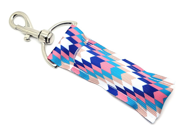 Desert Breeze Southwest Lip Balm Holder

Capture the essence of a pastel desert sunset with our Desert Breeze Lip Balm Holder!
This gorgeous accessory showcases a dynamic V-pattern made from blocked arrow shapes in shades of soothing blue, turquoise, pink, tan, and crisp white — all inspired by the gentle, colorful skies of the Southwest.

Perfectly practical and undeniably stylish, this holder clips easily onto your keys, bag, backpack, or purse so you can always keep your lip balm close, no matter where the breeze takes you.

Why You'll Love It:

Never Lose Your Lip Balm Again
Our secure swivel clasp keeps your favorite balm exactly where you need it — whether clipped to your tote, purse, or keychain.

Southwest-Inspired Elegance
The beautiful blend of turquoise, tan, pink, and blue tones channels a calm desert evening. Unique, artistic, and vibrant!

Handmade Quality
Each lip balm holder is handmade in the USA with durable, high-quality fabric and hardware for a product that’s as lasting as it is lovely.

Gift-Ready
Looking for a thoughtful, practical gift? "Desert Breeze" is perfect for:

Boho lovers

Southwestern fashion fans

Birthday surprises

Mother’s Day baskets

Teacher gifts

Holiday stocking stuffers

100% Satisfaction Guarantee
We proudly stand behind every holder. If you don’t absolutely love it, you’re covered with our no-questions-asked Money-Back Guarantee!

Product Details:

Size: 6.5 inches (including clasp) x 1.5 inches

Material: Durable woven fabric with premium hardware

Includes: 1 Desert Breeze Lip Balm Holder

Note: Lip balm not included — pair it with our Gettin’ Lippy balms!

Handmade with Love in the USA