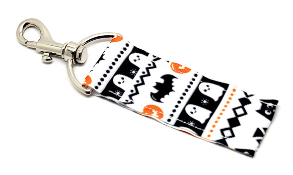 Cascading Halloween Lip Balm Holder – A Haunted Fall Favorite!

Elevate your spooky season style with our Cascading Halloween Lip Balm Holder, where classic Halloween icons flow together in one eye-catching design! With a crisp white background, this holder features an intricate cascade of white ghosts, black bats, orange pumpkins, black owls, and other delightfully spooky elements.

It’s hauntingly cute, wildly practical, and ready to keep your lip balm within reach all October long—and beyond!

Why You’ll Love It:
No More Lost Lip Balm

Keep your balm handy at all times! Clip it onto your keys, purse, backpack, or lanyard with the secure swivel clasp and never dig through your bag again.

Bold, Cascading Design

This detailed pattern perfectly blends classic Halloween characters in a dynamic fall design that stands out in the best way. Perfect for spooky vibes without being too scary!

Handmade in the USA

Crafted with care and built to last, this lip balm holder is made from high-quality materials and stitched with attention to detail.

Perfect For:

Halloween Boo Baskets

Fall gifts for kids, teens, and teachers

Spooky-chic accessories

Trick-or-treat swaps

Horror or fall décor fans

Everyday fall lovers looking to carry spooky vibes

Buy With Confidence

Our Gettin’ Lippy Lip Balm Holders are top-rated for both quality and charm. We offer a 100% Money-Back Guarantee—if you’re not obsessed, we’ll make it right!

Product Details:

Dimensions: 6.5 inches (with hook) x 1.5 inches

Includes: 1 Cascading Halloween Lip Balm Holder

Note: Lip balm not included. Browse our Halloween Lip Balm 3-Packs for perfect pairings!

Handmade in the USA – Get your spooky style on point this fall!