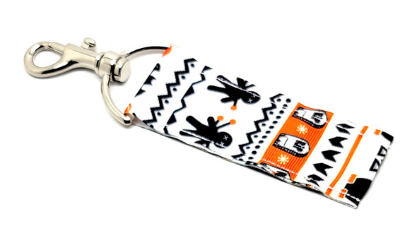 Cascading Halloween Lip Balm Holder – A Haunted Fall Favorite!

Elevate your spooky season style with our Cascading Halloween Lip Balm Holder, where classic Halloween icons flow together in one eye-catching design! With a crisp white background, this holder features an intricate cascade of white ghosts, black bats, orange pumpkins, black owls, and other delightfully spooky elements.

It’s hauntingly cute, wildly practical, and ready to keep your lip balm within reach all October long—and beyond!

Why You’ll Love It:
No More Lost Lip Balm

Keep your balm handy at all times! Clip it onto your keys, purse, backpack, or lanyard with the secure swivel clasp and never dig through your bag again.

Bold, Cascading Design

This detailed pattern perfectly blends classic Halloween characters in a dynamic fall design that stands out in the best way. Perfect for spooky vibes without being too scary!

Handmade in the USA

Crafted with care and built to last, this lip balm holder is made from high-quality materials and stitched with attention to detail.

Perfect For:

Halloween Boo Baskets

Fall gifts for kids, teens, and teachers

Spooky-chic accessories

Trick-or-treat swaps

Horror or fall décor fans

Everyday fall lovers looking to carry spooky vibes

Buy With Confidence

Our Gettin’ Lippy Lip Balm Holders are top-rated for both quality and charm. We offer a 100% Money-Back Guarantee—if you’re not obsessed, we’ll make it right!

Product Details:

Dimensions: 6.5 inches (with hook) x 1.5 inches

Includes: 1 Cascading Halloween Lip Balm Holder

Note: Lip balm not included. Browse our Halloween Lip Balm 3-Packs for perfect pairings!

Handmade in the USA – Get your spooky style on point this fall!
