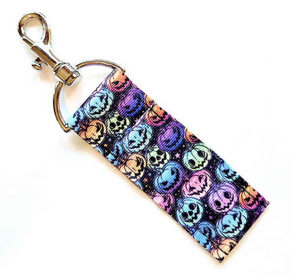 Pastel Pumpkin Party Lip Balm Holder

Description:
Bright, bold, and perfectly spooky — our Pastel Pumpkin Party Lip Balm Holder is the ultimate Halloween accessory for those who love a little color with their creepy! Featuring a sleek black background covered in vibrant pastel pumpkins, each carved with its own unique face — cute, scary, and fun, this holder is a total Halloween vibe.

From soft pinks and mint greens to electric oranges and purples, these playful pumpkins make it easy to show off your spooky spirit in style. Clip it to your keys, purse, or backpack and never lose your favorite lip balm again!

And don’t forget — these holders pair perfectly with our Halloween lip balms, safety keychain wristlets, and hydrating body products like our Whipped & Drench Body Butters and Island Radiance Body Scrub. Keep your lips (and skin!) hydrated all season long while rocking a little haunted glam.

Why You’ll Love It

Cute + Creepy Design: Pastel-colored pumpkins with expressive carved faces — from sweet to spooky — make this holder a Halloween must-have.

High-Quality Printed Fabric: Durable, soft, and vibrant — built to last well past pumpkin season.

No More Lost Lip Balm: The sturdy swivel clasp clips easily to your purse, backpack, or keychain for on-the-go convenience.

Perfectly Matches Our Lip Balms: Coordinate with our Halloween lip balm flavors for a complete seasonal set.

Handmade in the USA: Each holder is crafted with care for quality and long-lasting use.

Perfect For:

Halloween lovers & fall fashion fans

Trick-or-treaters, teens, and teachers

Gifting or party favors

Anyone who loves colorful, spooky-cute accessories

Product Details

Dimensions: 6.5 inches (with hook) x 1.5 inches

Includes: 1 Lip Balm Holder (lip balm not included)

Material: High-quality printed fabric

Handmade in the USA

Pair it with our 3-layer Halloween lip balms, safety keychain wristlets, and body care favorites for the full Gettin Lippy Halloween Collection experience!