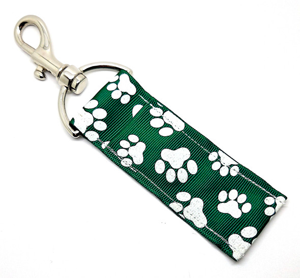 “Stay Pawsitive” – Hunter Green Glitter Paw Print Lip Balm Holder

Whether you’re cheering for your favorite team, supporting your school, or simply obsessed with anything paw-print cute — the Stay Pawsitive Lip Balm Holder is the perfect little pop of pet-lovin’ personality!

This version features a deep hunter-green background covered in sparkling white glitter paw prints, giving it a bold, spirited, stylish vibe. Perfect for pet lovers, teachers, students, and anyone who wants to add a little pawsitive energy to their day!

Clip it onto your keys, backpack, lanyard, or purse, and keep your lip balm easy to find and impossible to lose — all while repping your love of animals and your favorite team colors.

Why You’ll Love It

Glitter Paw Prints:
Beautiful white glitter paws pop against a deep hunter-green base for a rich, eye-catching look.

Pet-Lover Approved:
Ideal for dog moms, cat dads, and anyone who swoons over furry friends.

School Spirit Ready:
Perfect for schools or teams with green-and-white colors!

Functional + Adorable:
Clips easily to your bag, purse, backpack, or keys — keeping your lip balm ready at all times.

Handmade in the USA:
Crafted with love, care, and serious paw-sitivity.

Product Details

Size: Approx. 6.5" x 1.5"

Material: High-quality printed fabric

Includes: 1 “Stay Pawsitive” lip balm holder (lip balm not included)

Handmade in the USA
