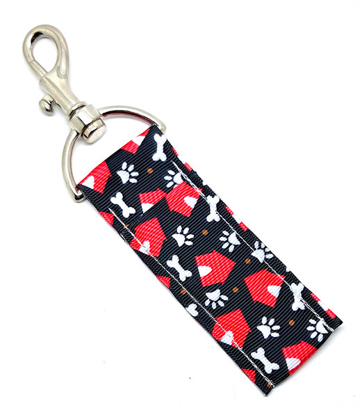 Home Is Where the Dog Is – Red Dog House Lip Balm Holder

Calling all dog lovers — this one is for the humans who proudly admit they live in their dog’s house!

The Home Is Where the Dog Is Lip Balm Holder features a bold black background decorated with bright red dog houses, white bones, and white paw prints scattered all over. It’s the perfect mix of playful, stylish, and totally dog-obsessed.

Clip it onto your keys, purse, backpack, lanyard, or dog-walking bag so your lip balm is always exactly where you need it — no digging, no losing it, no panic searches at the bottom of your bag.

Cute. Functional. And made for the ultimate dog parent.

Why You’ll Love It

Bold Dog House Design – Red dog houses pop against a black background with classic white bones and paws

Perfect for Dog Moms & Dog Dads – Great for pet owners, walkers, sitters, groomers, or anyone who loves pups

No More Lost Lip Balm – Swivel clasp keeps your chapstick secure and easy to grab

Durable & Fun – High-quality fabric with a cute everyday vibe

Product Details

Size: Approx. 6.5" x 1.5"

Material: High-quality printed fabric

Includes: 1 Home Is Where the Dog Is lip balm holder (lip balm not included)

Handcrafted in the USA