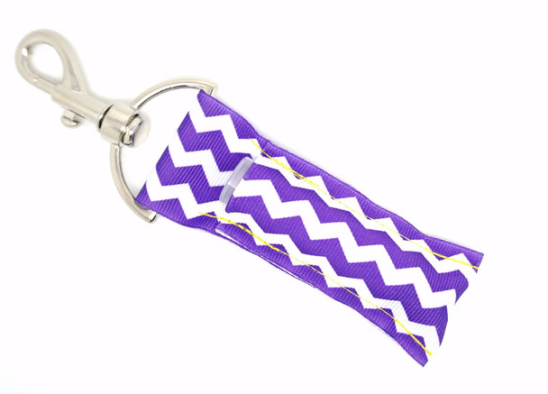 Violet Vibe Purple Chevron Lip Balm Holder ~ Lippy Clip Keychain

Elevate your essentials with Violet Vibe, a chic and eye-catching lip balm holder featuring a bold vertical white and purple chevron design. This striking pattern adds a playful punch of personality while keeping your favorite lip balm stylishly within reach.

Whether you're on-the-go, gifting a friend, or treating yourself, Violet Vibe brings convenience and color in the signature Gettin Lippy style.

Why You’ll Love It:

Unique white and purple chevron pattern (vertical orientation)

Fits most standard lip balm tubes, chapstick, and more

Silver lobster clasp attaches easily to keys, bags, backpacks & more

Handmade with high-quality printed fabric

A fun, functional gift for anyone who loves pops of purple

Product Details:

Design: Vertical white and purple chevron pattern

Material: High-quality printed fabric

Clip: Silver lobster clasp

Fits: Standard lip balm tubes (not included)

Includes: 1 Violet Vibe lip balm holder

Handmade by Gettin Lippy in the USA!