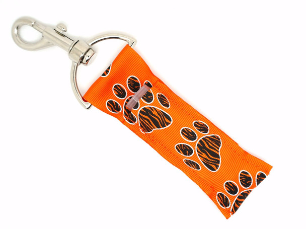 Savanna Spirit – Orange Zebra Paw Lippy Clip

Let your fierce and fearless side shine with the Savanna Spirit lippy clip! This bold and fiery design features a bright orange background with oversized paw prints, each with striking black zebra print detail in the center. Whether you're repping your team, showing school spirit, or just wild about prints, this lip balm holder is the ultimate accessory for bold personalities.

Clip it to your backpack, purse, or keys and never dig for your lip balm again!

Why You’ll Love It:

Bold Zebra Paw Prints – Black zebra print inside large paw shapes
Fiery Orange Base – Eye-catching and energetic
Clip-On Convenience – Attach to keys, bags, lanyards & more
Lip Balm Ready – Fits standard-size lip balm tubes
Perfect Gift – Great for animal lovers, team moms, and spirited friends

Product Details:

Design: Orange fabric with large black zebra paw prints

Material: High-quality printed fabric

Clip: Durable lobster clasp for easy attachment

Fits: Standard lip balm tubes or essential oil rollers

Includes: 1 Savanna Spirit lip balm holder (lip balm not included)

Handmade with love by Gettin Lippy in the USA