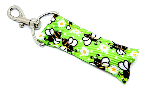 Bee Kind Bloom – Green Bee & Daisy Lip Balm Holder

Fresh like spring and sweet as honey, our Bee Kind Bloom lip balm holder is buzzing with style! With a soft green background, whimsical sketched bees, and dainty little daisies, this design is perfect for those who love a natural, playful look.

Whether you're headed to the garden, the classroom, or a picnic in the park — this cute lip balm holder will bring a smile to your face every time you reach for your balm.

Why You'll Love It:

Sweet Springtime Vibes
Sketched bees and cheerful daisies float across a soft green background — calm, cozy, and adorable.

Clip and Go
Comes with a strong metal clasp that easily attaches to keys, bags, backpacks, and more — keep your balm right where you need it.

Handmade With Care
Crafted in the USA from durable fabric and quality hardware, made to last season after season.

Perfect Gift For:

Bee lovers

Gardeners

Teachers & students

Earthy, nature-loving friends

Spring birthdays & Easter baskets

Product Details:

Size: Approx. 6.5" long (including clip) x 1.5" wide

Material: Durable woven fabric with secure metal clasp

Includes: 1 Bee Kind Bloom lip balm holder

Note: Lip balm not included

Handmade in the USA