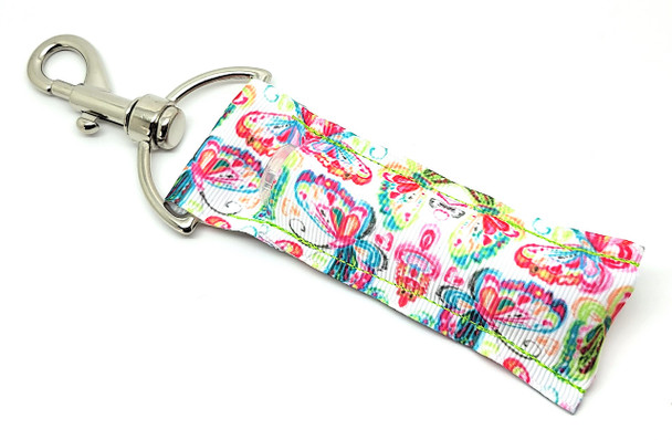 Butterfly Kisses – Rainbow Butterfly Lip Balm Holder

Bring a little joy and a lot of color wherever you go with our Butterfly Kisses Lip Balm Holder! This playful accessory features a flurry of bright rainbow-toned butterflies fluttering across a clean white background — like a field of charm in your pocket!

Whether you're adding a pop of color to your day or gifting someone a little magic, this rainbow-inspired lip balm holder is full of happy vibes.

Why You'll Love It:

Rainbow Butterfly Charm
Every butterfly on this design boasts its own unique splash of color, from vibrant pinks and teals to sunny yellows and deep purples — pure eye candy for the butterfly lover!

Clip and Go
Equipped with a sturdy swivel clasp that latches onto keys, backpacks, totes, or handbags so you’ll never misplace your lip balm again.

Handmade Happiness
Proudly handmade in the USA with premium woven fabric and high-quality stitching for durability and style.

A Perfect Gift For:

Butterfly collectors

Colorful personalities

Kids & teens

Cheerful gift baskets

Easter baskets, birthdays, or just because

Pride celebrations or rainbow-themed gifts

100% Satisfaction Guarantee
Love it or send it back — we make returns easy and stress-free.

Product Details:

Size: 6.5 inches (including clasp) x 1.5 inches

Material: Durable woven fabric with premium hardware

Includes: 1 Butterfly Kisses Lip Balm Holder

Note: Lip balm not included

Handmade with love in the USA