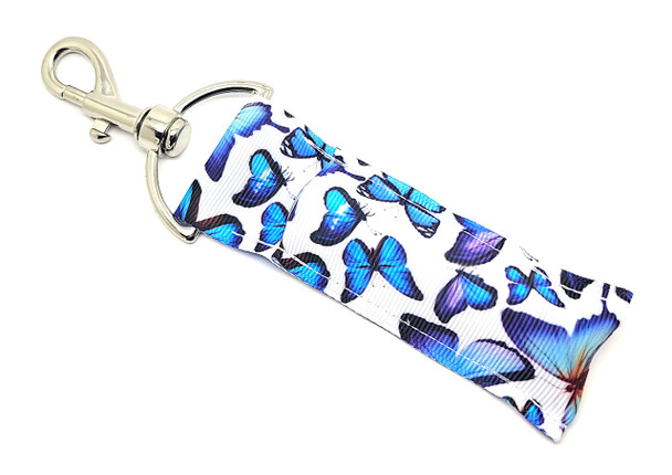 Moonlit Wings Lip Balm Holder – Where Magic Meets Function

Let your imagination take flight with our Moonlit Wings Lip Balm Holder! This ethereal design features delicate butterflies in soothing shades of dreamy purples and tranquil blues, floating across a clean white background like a midnight garden in bloom.

Whimsical and practical, this charming accessory keeps your lip balm close at hand and adds a magical touch to your daily essentials — a perfect pick for butterfly fans, fantasy lovers, or anyone who adores soft, serene color palettes.

Why You'll Love It:

Elegant Butterfly Aesthetic
Purple and blue butterflies bring a serene, dreamy vibe to this design — gentle, graceful, and totally unique.

Clip & Carry Ease
Swivel clasp lets you attach it to your purse, keys, gym bag, or backpack for on-the-go convenience.

Handmade Charm
Crafted with love in the USA using quality fabric and sturdy metal hardware that lasts and looks beautiful.

Makes a Magical Gift for:

Butterfly and nature lovers

Teen and pre-teen girls

Fantasy and fairytale fans

Easter baskets & birthday gifts

Thoughtful teacher appreciation

Stocking stuffers

100% Satisfaction Guarantee
We believe in the magic of a perfect accessory. Love it or your money back — no questions asked!

Product Details:

Size: 6.5 inches (including clasp) x 1.5 inches

Material: High-quality woven fabric + premium swivel clasp

Includes: 1 “Moonlit Wings” Lip Balm Holder

Note: Lip balm not included

Handmade in the USA