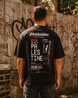 Black oversized t-shirt back print styled as an airline boarding pass reading Freedom, Palestine, one way to Palestine, with barcode, coordinates, barbed wire graphic and Resist Occupation Stand For Humanity End The Genocide text