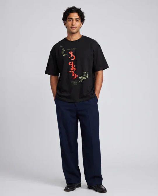 Black short sleeve t-shirt with "From My Eyes" in English and Arabic in orange lettering, sage green olive branch motif, and Toronto Palestine Film Festival wordmark