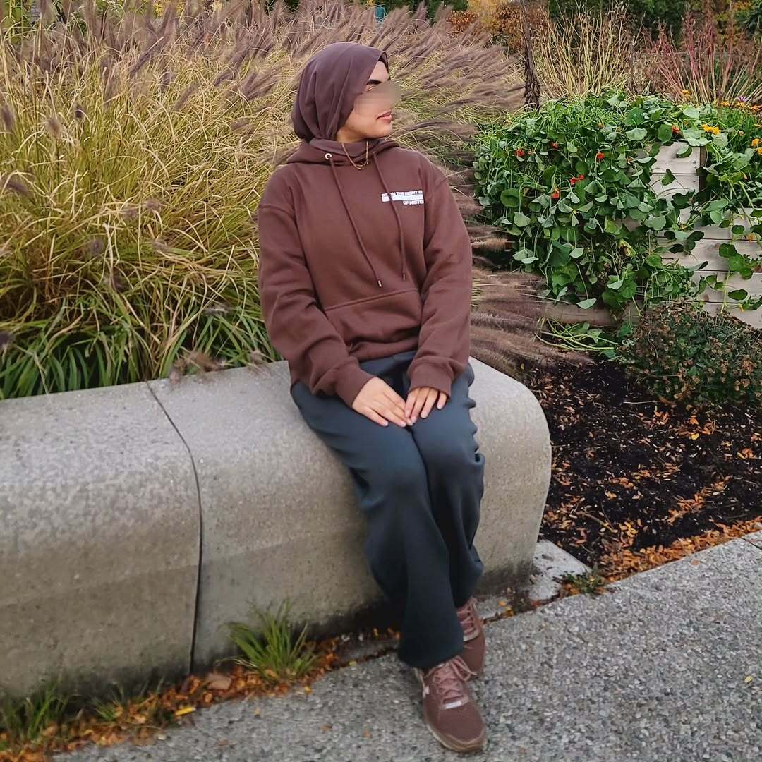 Customer wearing brown hoodie in garden