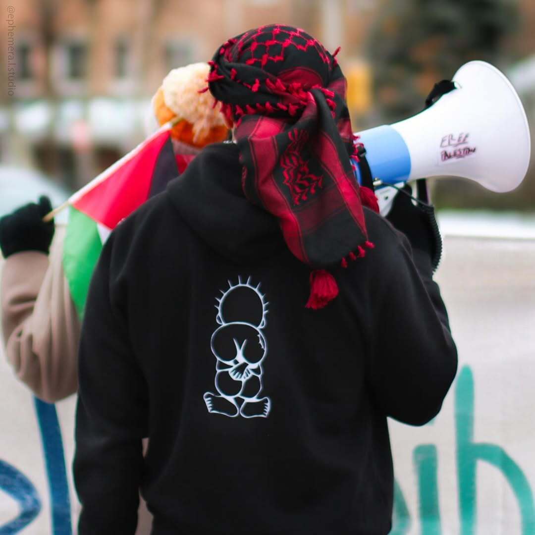 Customer wearing Handala hoodie at rally