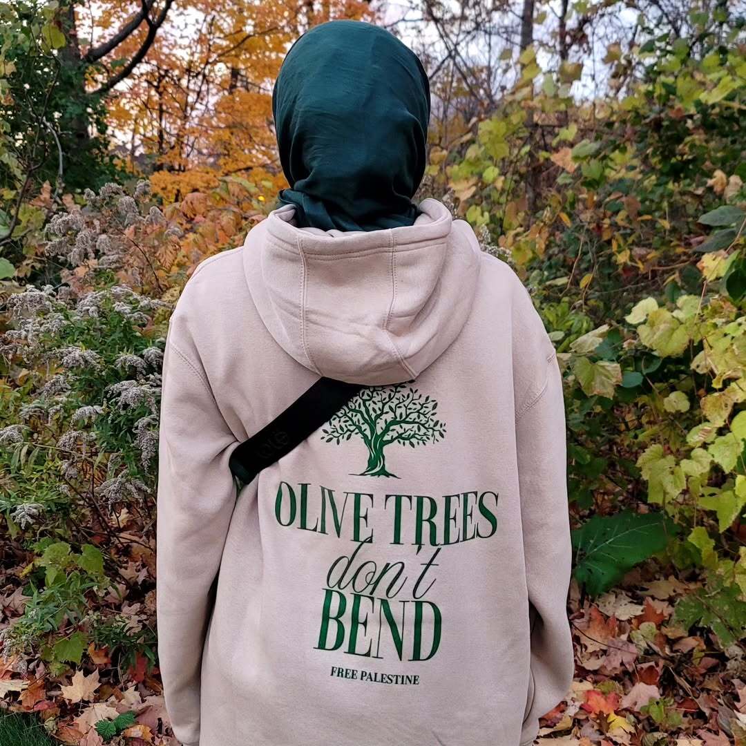 Customer wearing Olive Trees Don't Bend hoodie