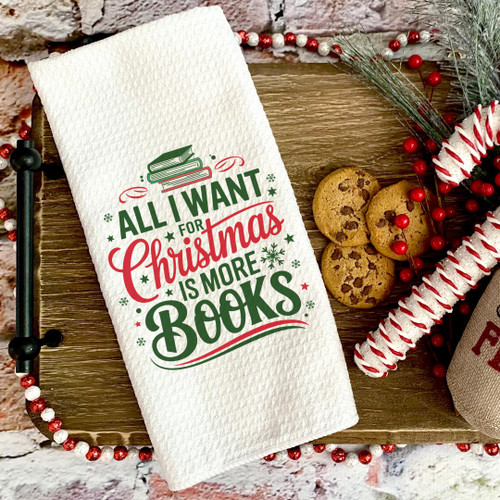 'All I Want for Christmas is More Books' kitchen towel flat lay styled on wooden tray with Christmas cookies and holiday greenery