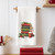 All Booked for Christmas' dish towel hanging in cozy decorated holiday kitchen — book lover Christmas décor and unique teacher gift idea