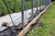 High tunnel wooden baseboard system with roll-up side support hardware
