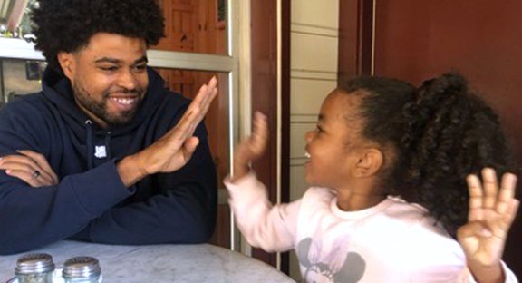 Father and daughter smiling and high fiving