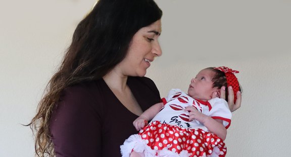 Mother holding and smiling at daughter