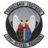 Circular embroidered patch with black field, gray border, gray scrolls reading "Servatoris Taciturn" at top and "131st Rescue Squadron" at bottom, winged angel over a blue and red globe with parachute canopy above.