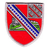 Red shield-shaped 17th Field Artillery Regiment patch with a castle on a green mount crossed by a silver band of blue stars and a striped canton in the corner, inside a silver merrowed border.