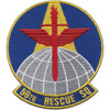 Circular embroidered patch with royal blue field, gold border, red Lorraine cross with red angled wings and gold torch at top, white gridded globe at base, and "56TH RESCUE SQ" gold scroll.