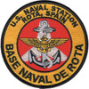 Round U.S. Naval Station Rota Spain patch with a silver fouled anchor and gold naval aviation wings on a red center, gold border lettered in black and a black merrowed edge.