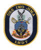 Oval USS Iwo Jima LHD 7 patch with gold rope border, eagle over crossed Navy and Marine swords, Suribachi flag raising on a blue shield, and red and gold Uncommon Valor scroll.