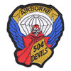 504th Parachute Infantry Regiment patch with a red devil in a red cape under a white parachute canopy, blue wings at the sides, AIRBORNE on a gold banner above and 504 DEVILS on a gold panel.