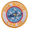Round USS Nimitz CVN 68 patch with a gray and blue aircraft carrier marked with a gold N, surrounded by five white stars on light blue inside a red circle and white ring.