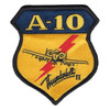 Shield-shaped A-10 Thunderbolt II patch with gold A-10 lettering on a navy band, a head-on A-10 outline over a red lightning bolt on a gold field, Thunderbolt II in black script and a black merrowed edge.