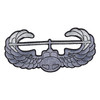 Gray and silver Air Assault Badge patch cut to shape, showing a helicopter nose-on with its rotor blade across the top and wings curling up at each end.