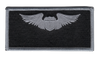 Silver and black rectangular name patch with pilot wings insignia and blank nameplate area, designed for flight suit wear with contrasting embroidery.