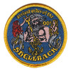 Round Ancient Order of the Shellback patch with bearded King Neptune holding a gold trident between two mermaids, a fouled anchor below and a gold merrowed edge.