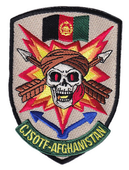 CJSOTF Afghanistan shield patch with skull in Afghan turban red eyes starburst explosion SF crossed arrows on desert tan background