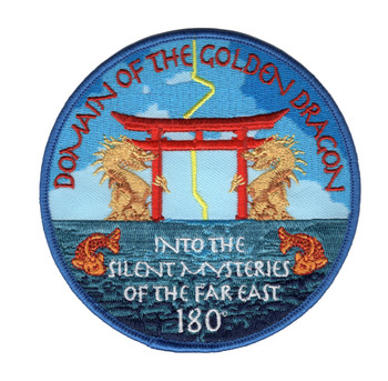 Circular embroidered patch with two gold dragons flanking a red torii gate over teal water, orange koi at lower left and right, red arc text reading 'Domain of the Golden Dragon' at top and white gothic script reading 'Into the Silent Mysteries of the Far East' and '180' at bottom, merrowed blue border.