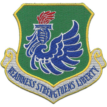Shield-shaped embroidered patch with green field, gold border, blue rearing Pegasus with wings spread at center, red torch above, and white scroll reading "Readiness Strengthens Liberty" at bottom.