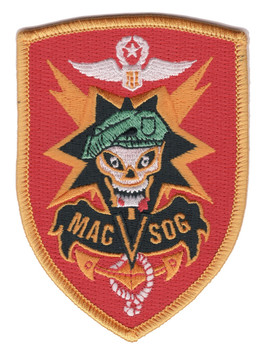 Red shield MACV-SOG patch with a skull in a green beret on a black and orange star burst, white wings above and MAC V SOG on a black banner.