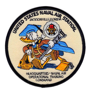 Round embroidered patch with cream background and black merrowed border showing Donald Duck in blue campaign cover and brown field gear carrying a rifle, with the NAOTC crest behind him and 'United States Naval Air Station Jacksonville Florida' and 'Headquarters Naval Air Operational Training Command' text surrounding the design.