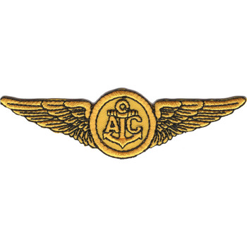 Gold embroidered Naval Aircrew AIC wings patch showing spread Navy wings flanking a central disc with fouled anchor and AIC rating letters, merrowed border, 4 inches wide.