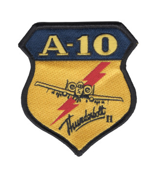 Shield-shaped A-10 Thunderbolt II embroidered military patch with navy blue header, gold body, red lightning bolt, front-quarter Warthog silhouette, and cursive Thunderbolt II script inscription