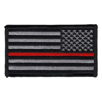 Subdued reverse American flag patch in gray and black with a single red stripe below the star field and a black merrowed edge.