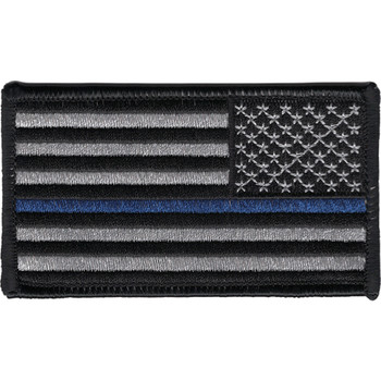 Rectangular embroidered American flag patch in subdued gray and black with a single thin blue stripe through the stripes field, reversed orientation for right-shoulder wear, black merrow border.